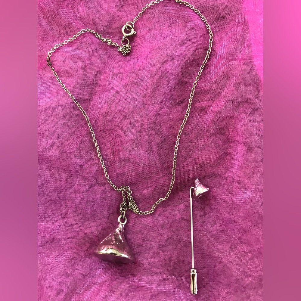 Vintage silver toned kisses stick pin and necklace.